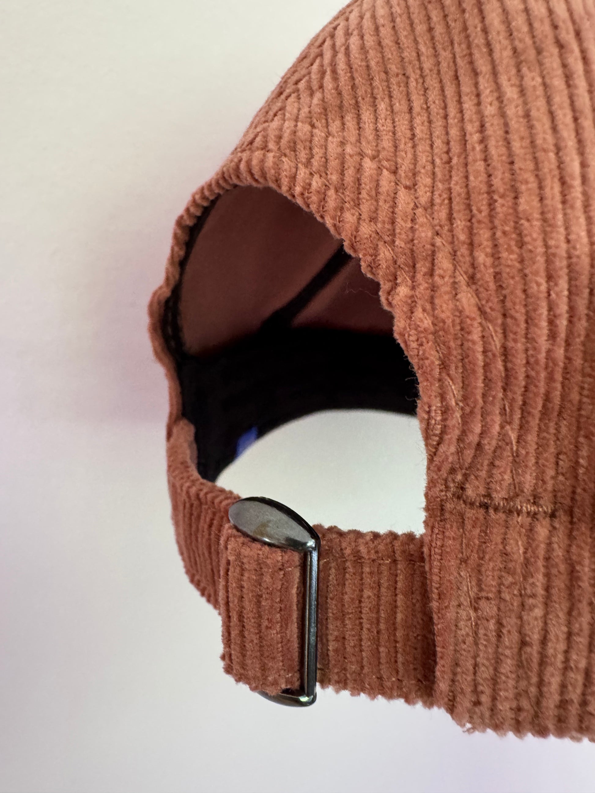 close up of NUADH DENIM - Sannox bay 6 panel surfer cap - cord fabric -  Pink - redwood colour with tonal lighter rose NUADH denim logo embroidery.