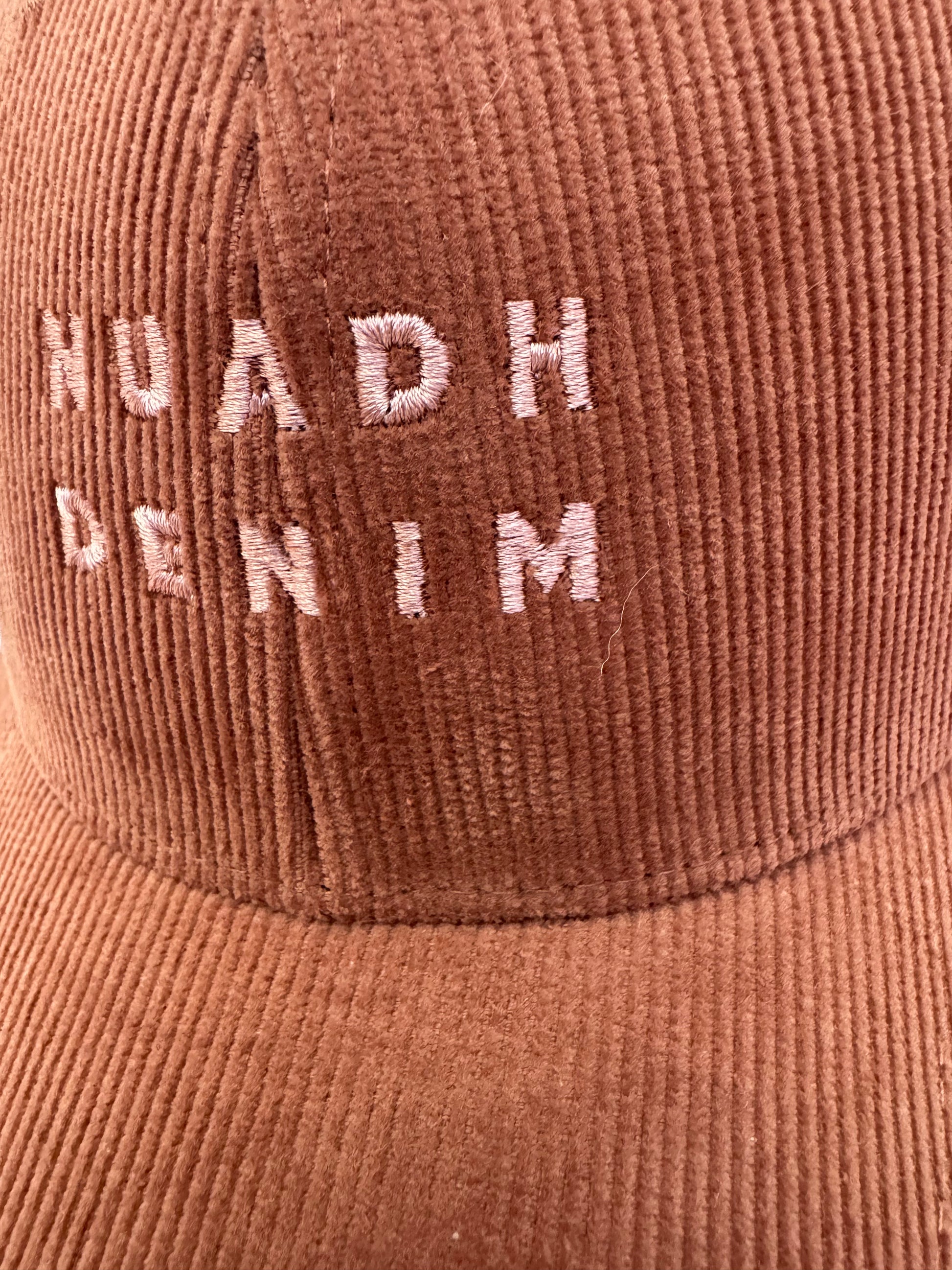 close up of NUADH DENIM - Sannox bay 6 panel surfer cap - cord fabric -  Pink - redwood colour with tonal lighter rose NUADH denim logo embroidery.